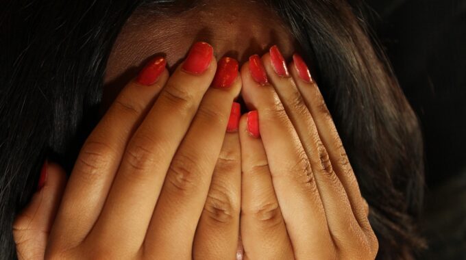 A woman hiding her face in fear